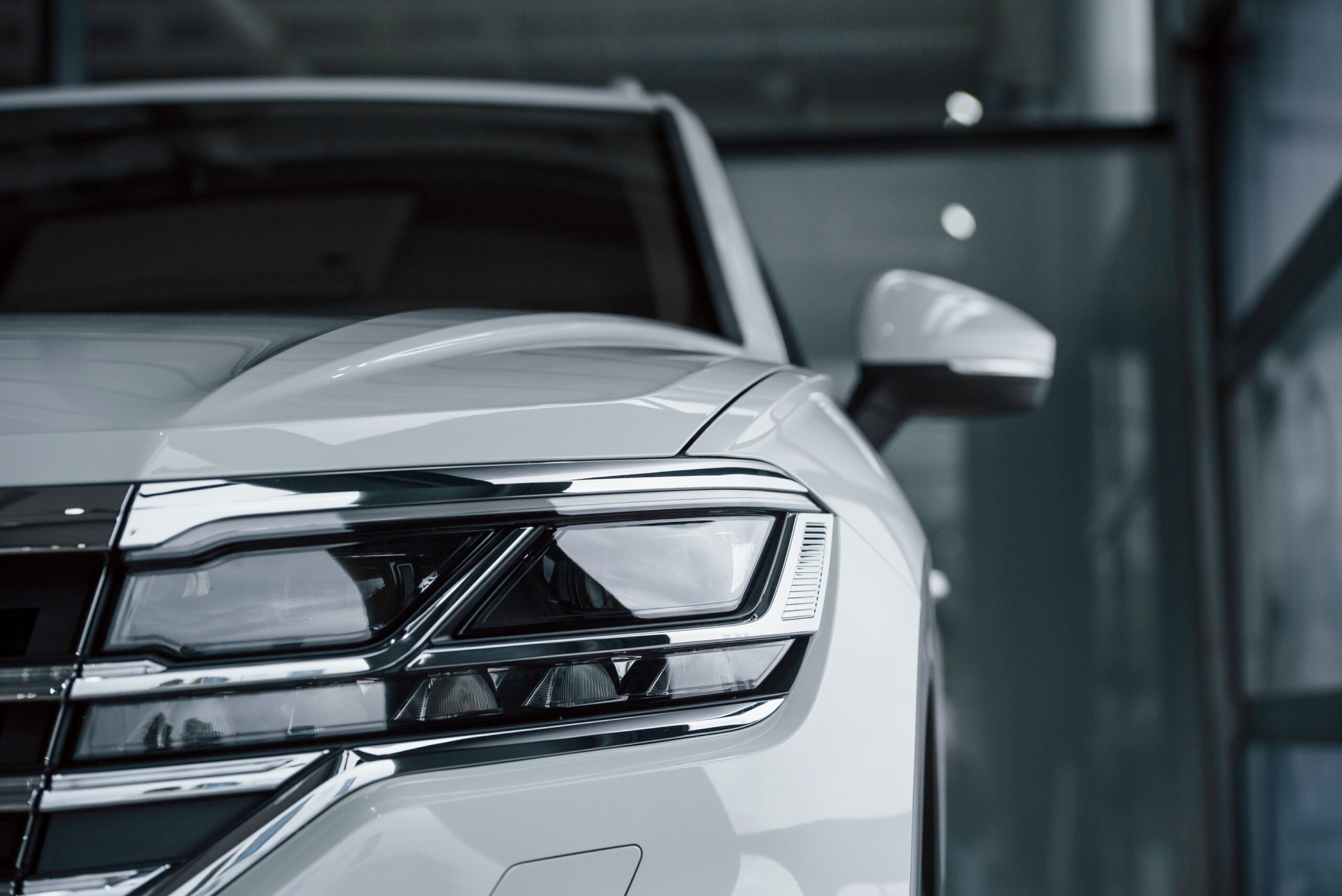 attention to details. particle view of modern luxury white car parked indoors at daytime
